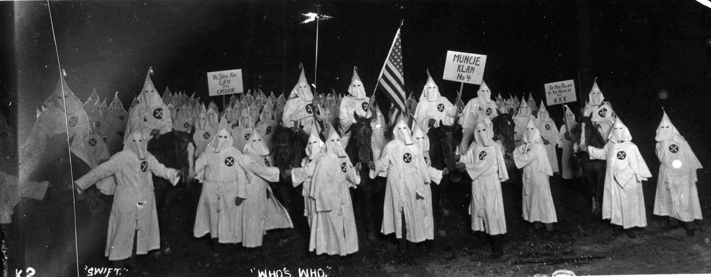 Picture of the KKK holding up signs at a rally