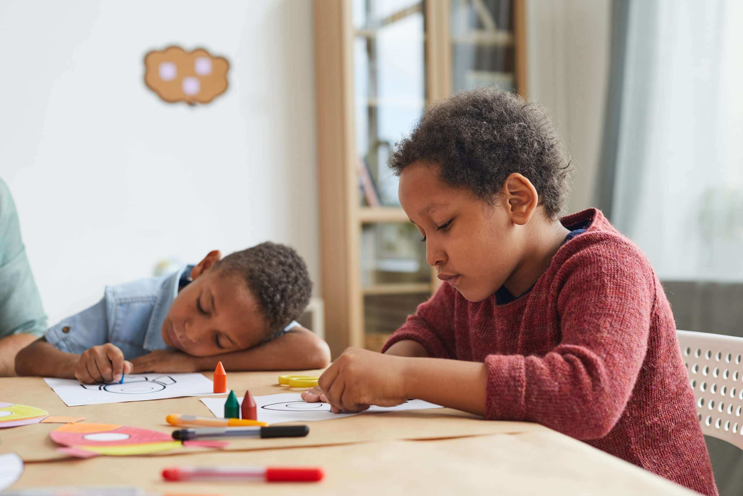 Black Kids doing homework with crayons in art