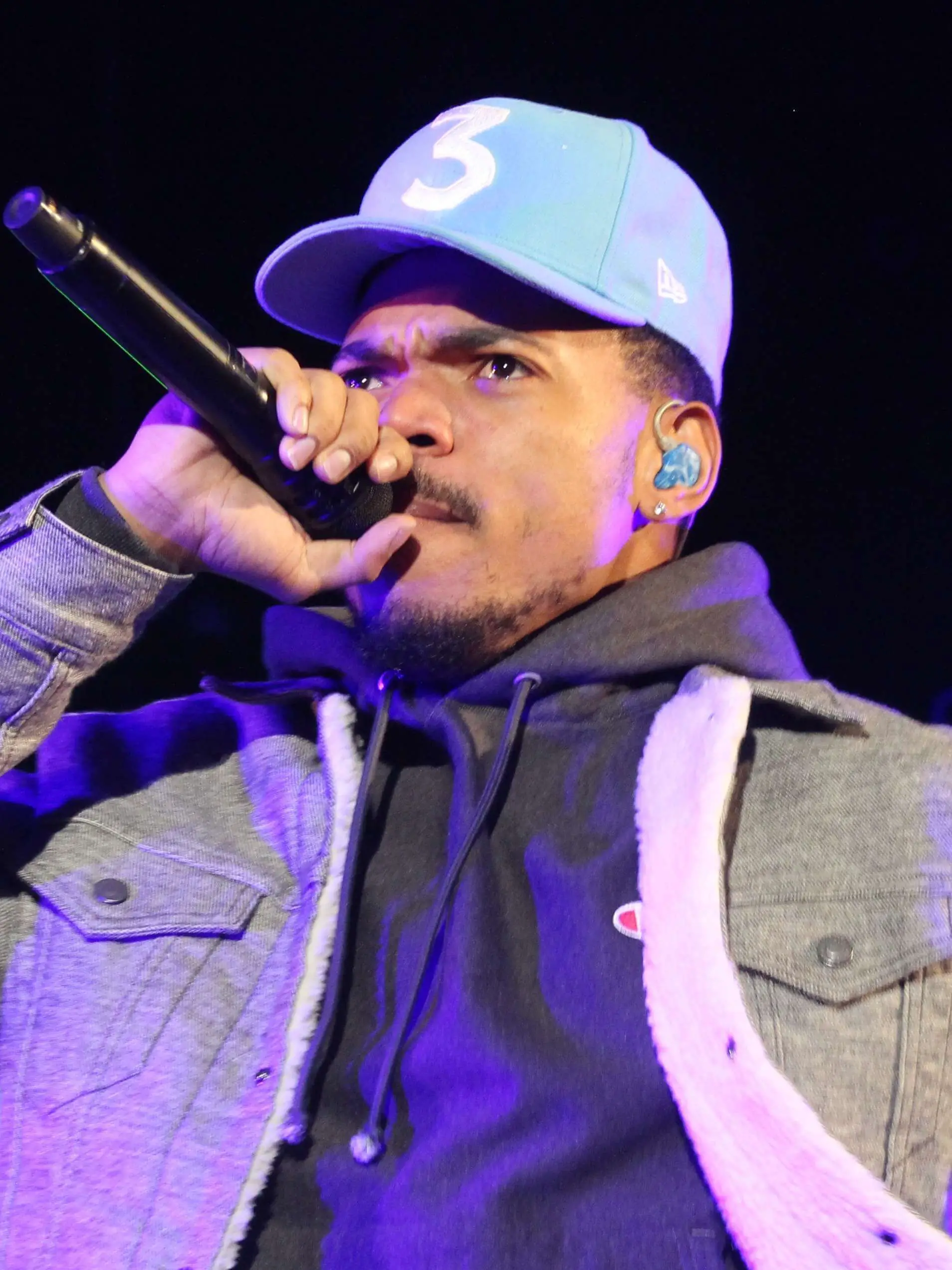 Chance the Rapper in 3 blue hat on stage