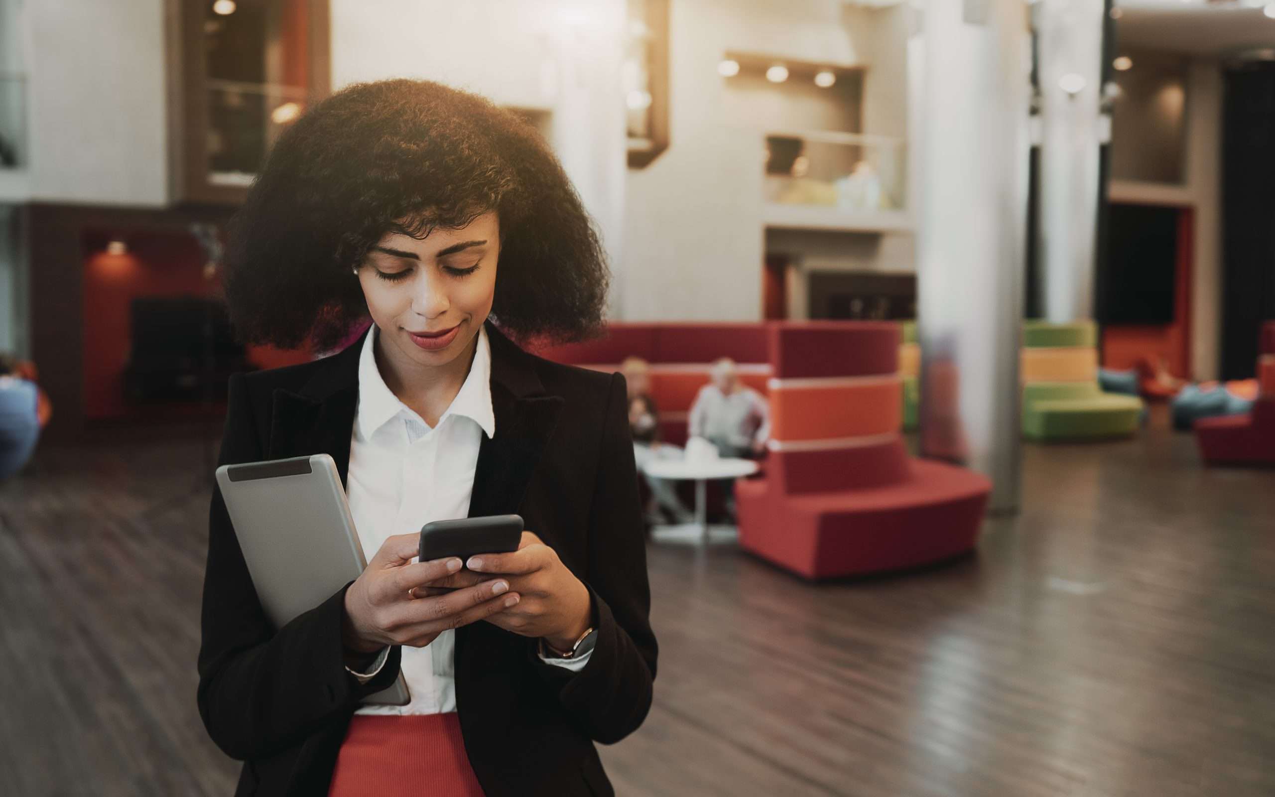 Black Biracial business women using phone and gadgets