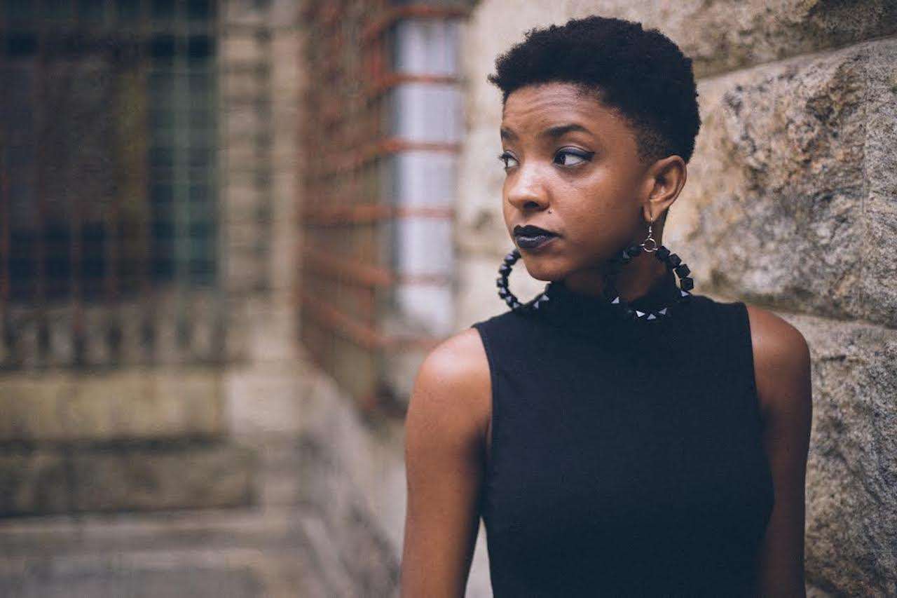 Black women in black with short hair style and black earring