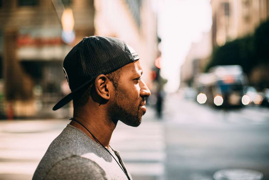 Black man with backward hat in the city