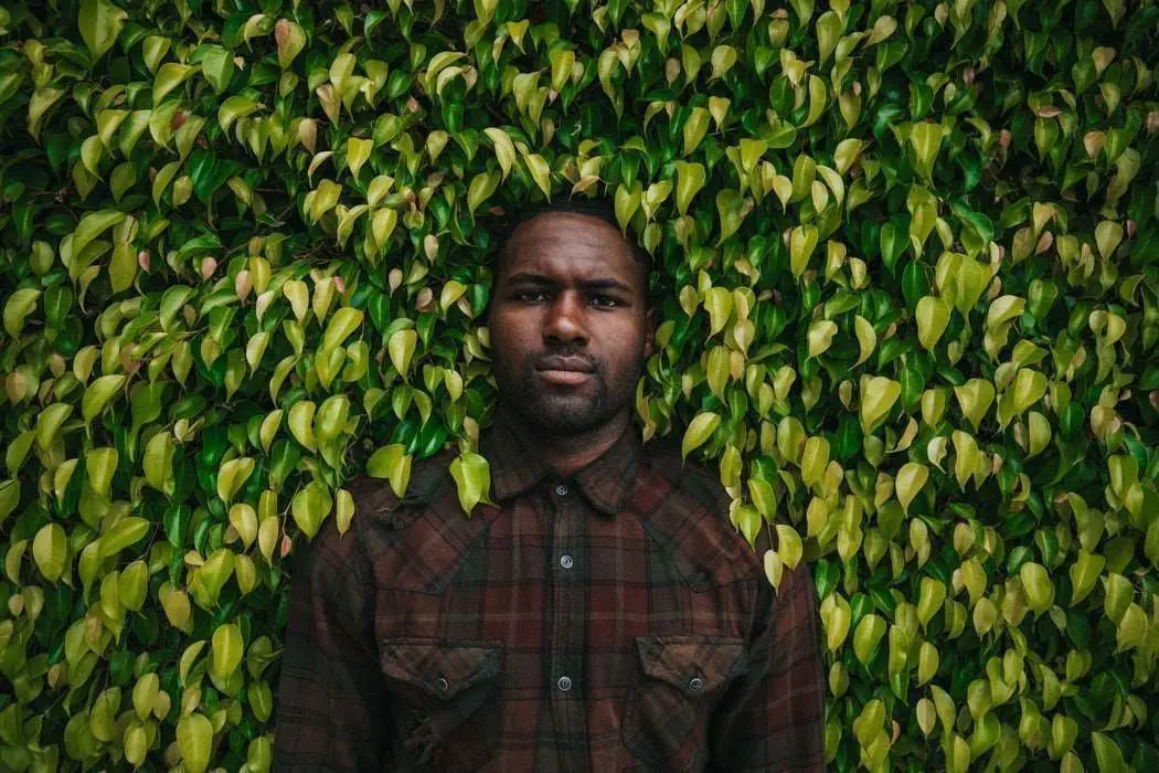 Black man depressed surround in trees and bushes