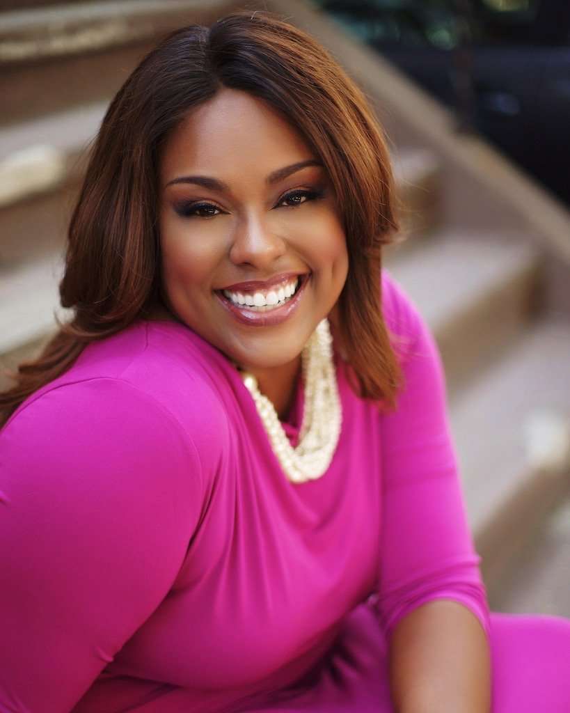 Black Female Entrepreneur smiling in pink dress