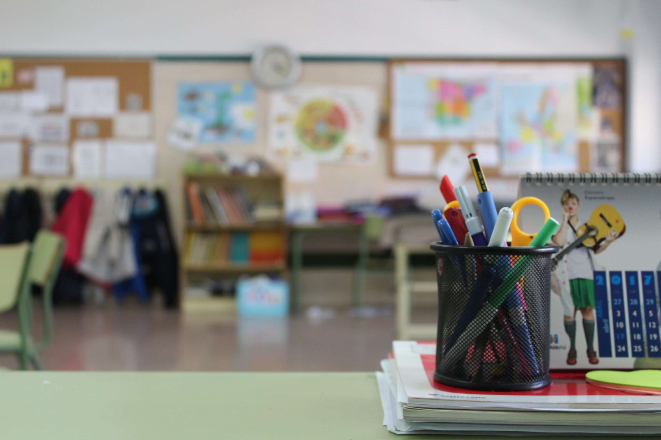 Inside of a clean classroom with pens and markers on the desk