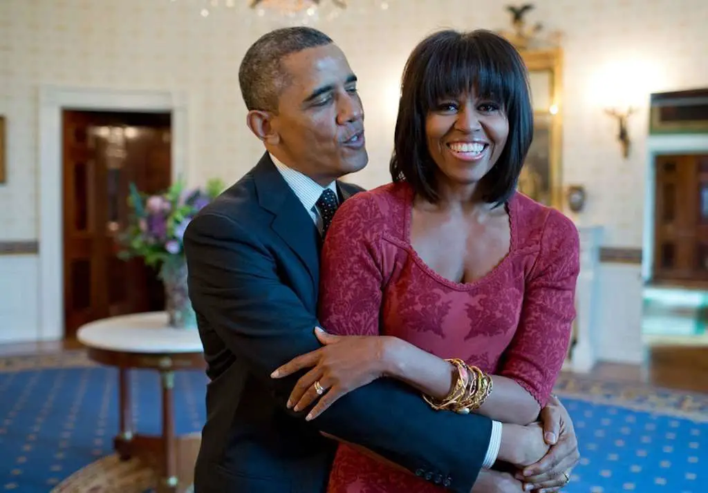 Barrack Obama holding Michelle Obama in the White House, Michelle Obama is smiling with a dress on
