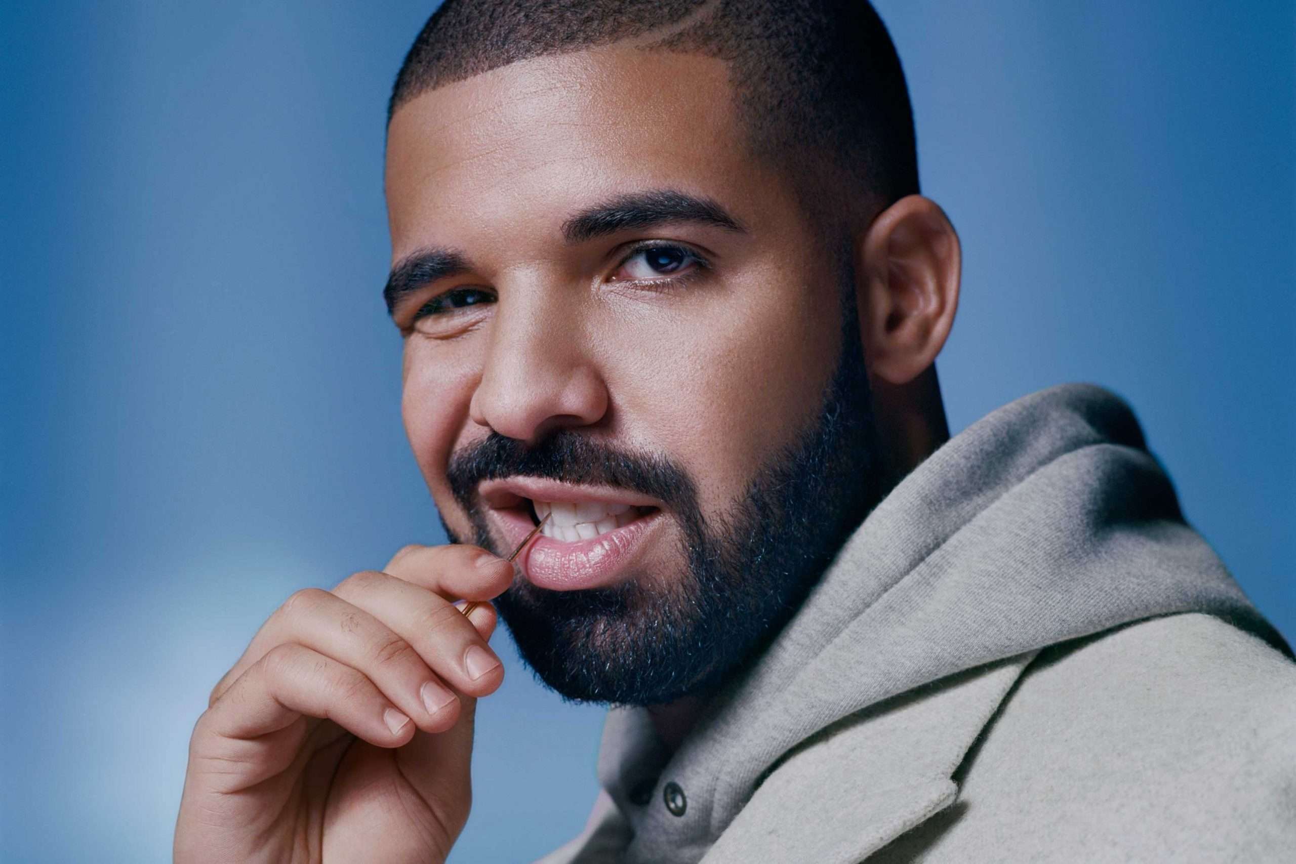 drake putting a tooth pick in his mouth looking at the camera