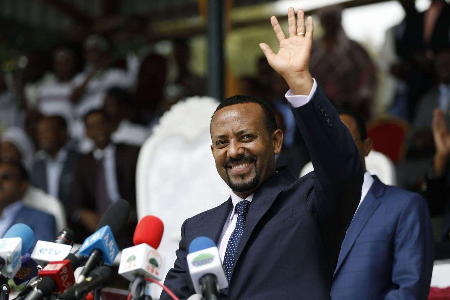 Abiy Ahmed holding up his hand after winning with suit and tie