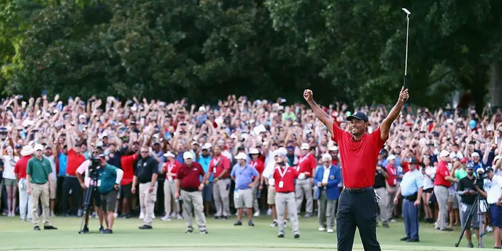 Tigres woods wins first victory since 2013 in Red Collard shirt and holding up a golf club