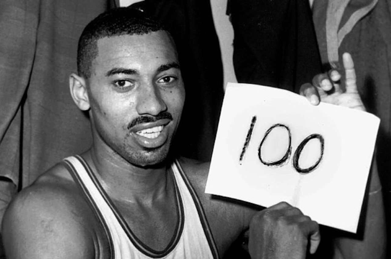 Wilt Chamberlain holding up a 100 point sign