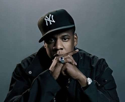 Jay Z with his hands crossed and Black New York Hat on