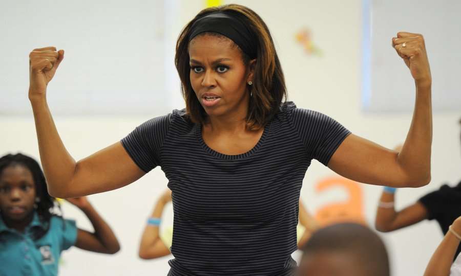 Michelle Obama teaching to young women with her hand up