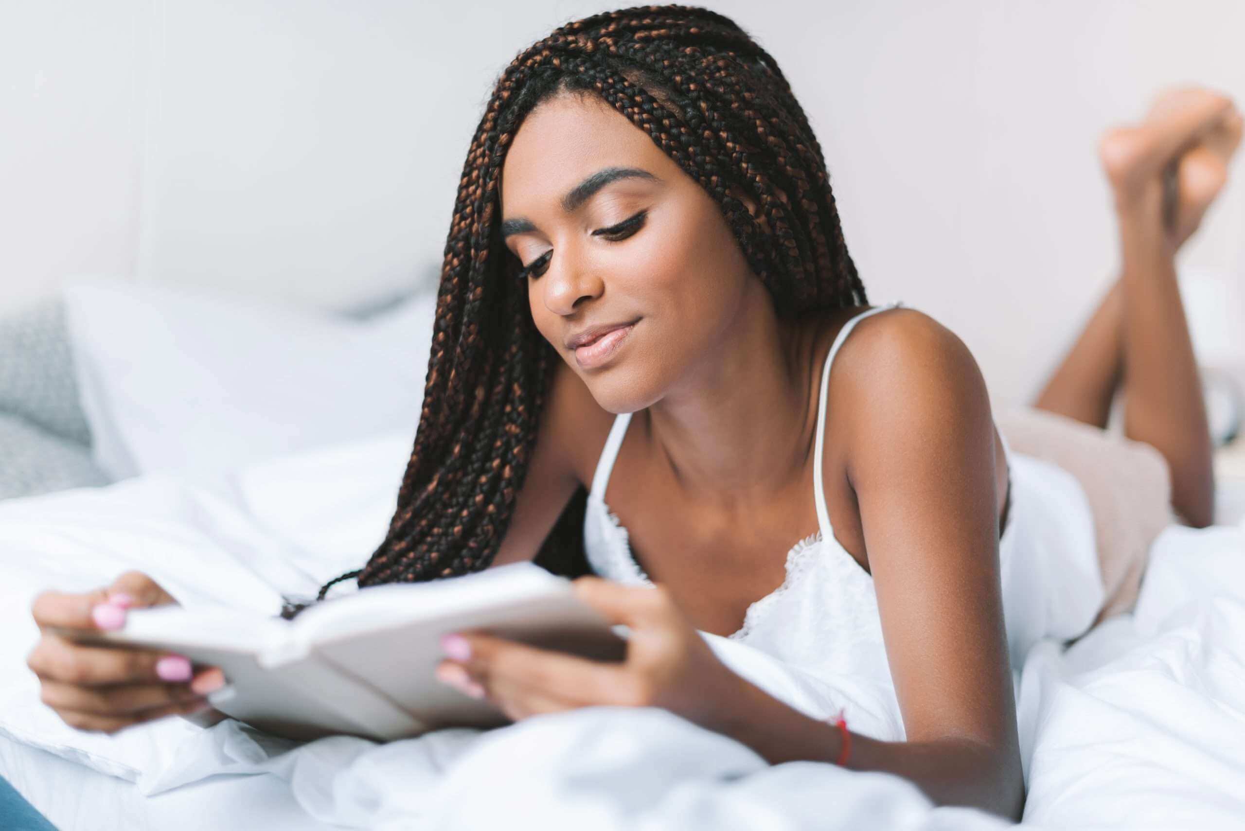 Pretty Black Girl with braids reading a book