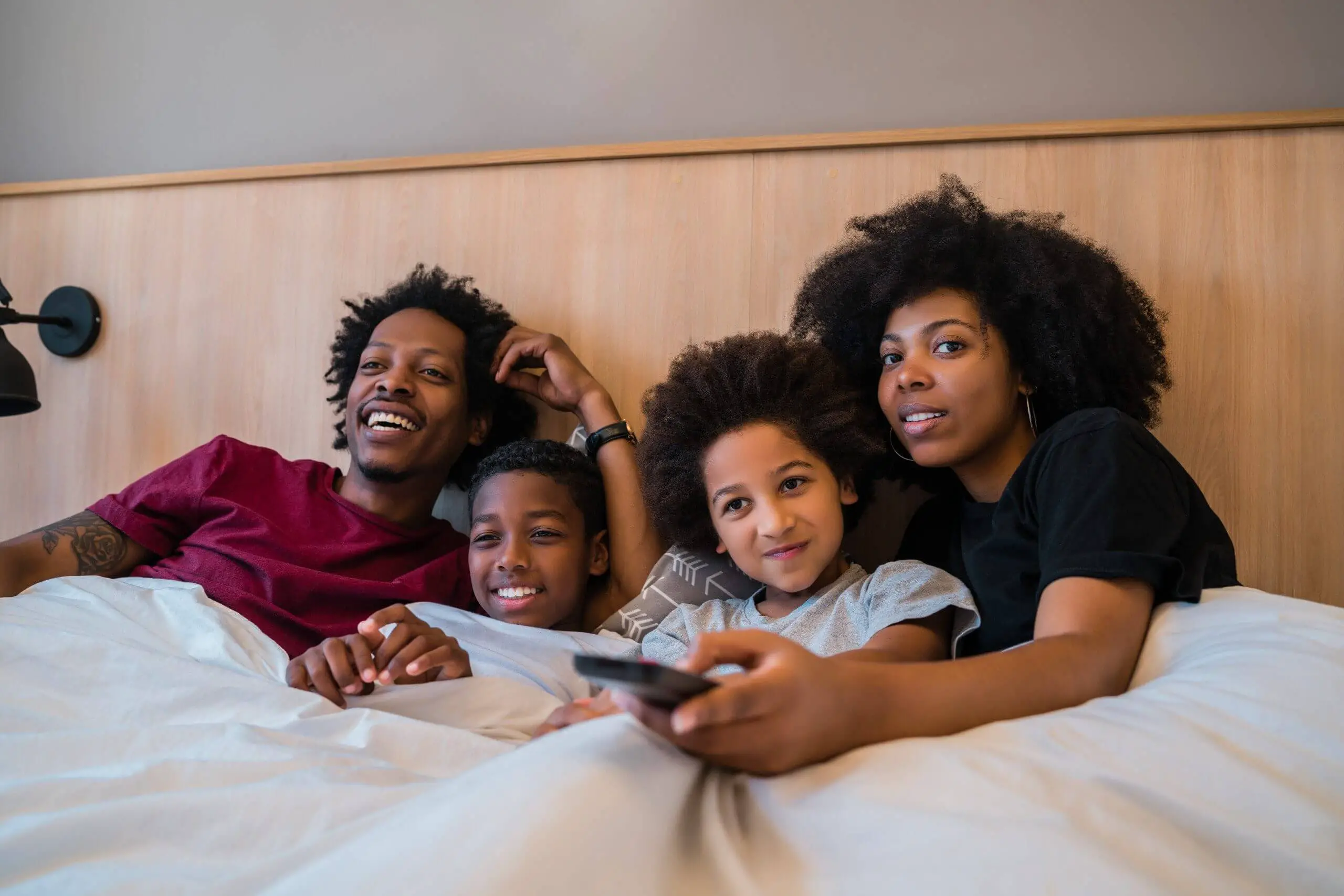 Black Family watching Tv in Bed