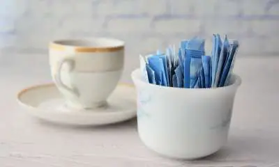 Sugar Substitute sweetener in a packet and cup of tea on table
