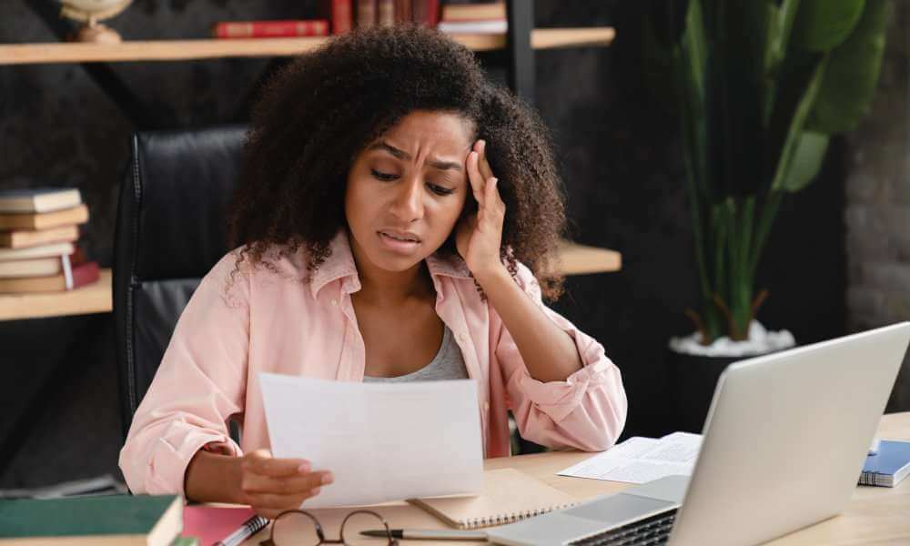 worried black woman looking at student loan debt