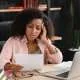 worried black woman looking at student loan debt
