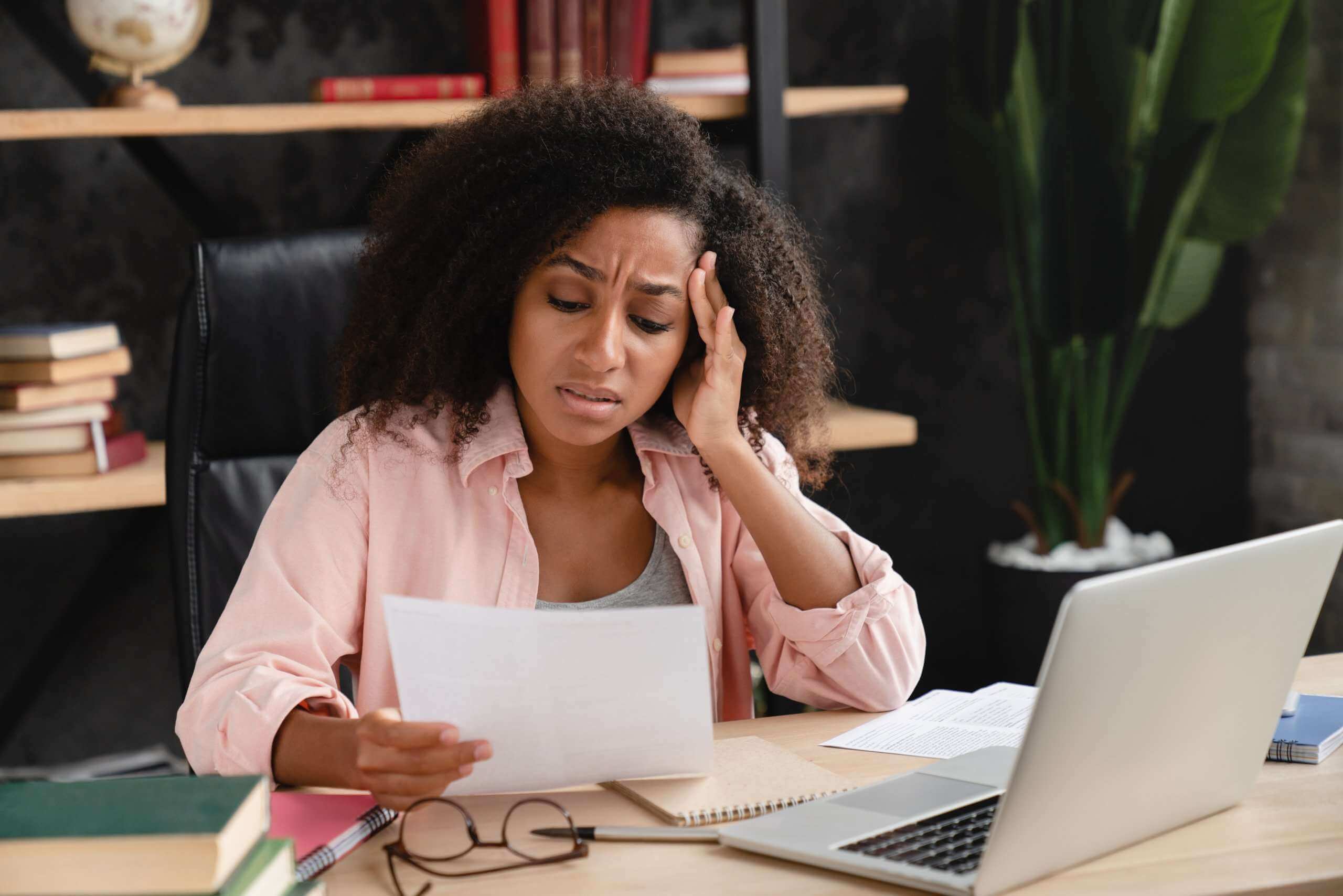 worried black woman looking at student loan debt