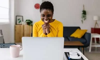 black woman looking at laptop excited